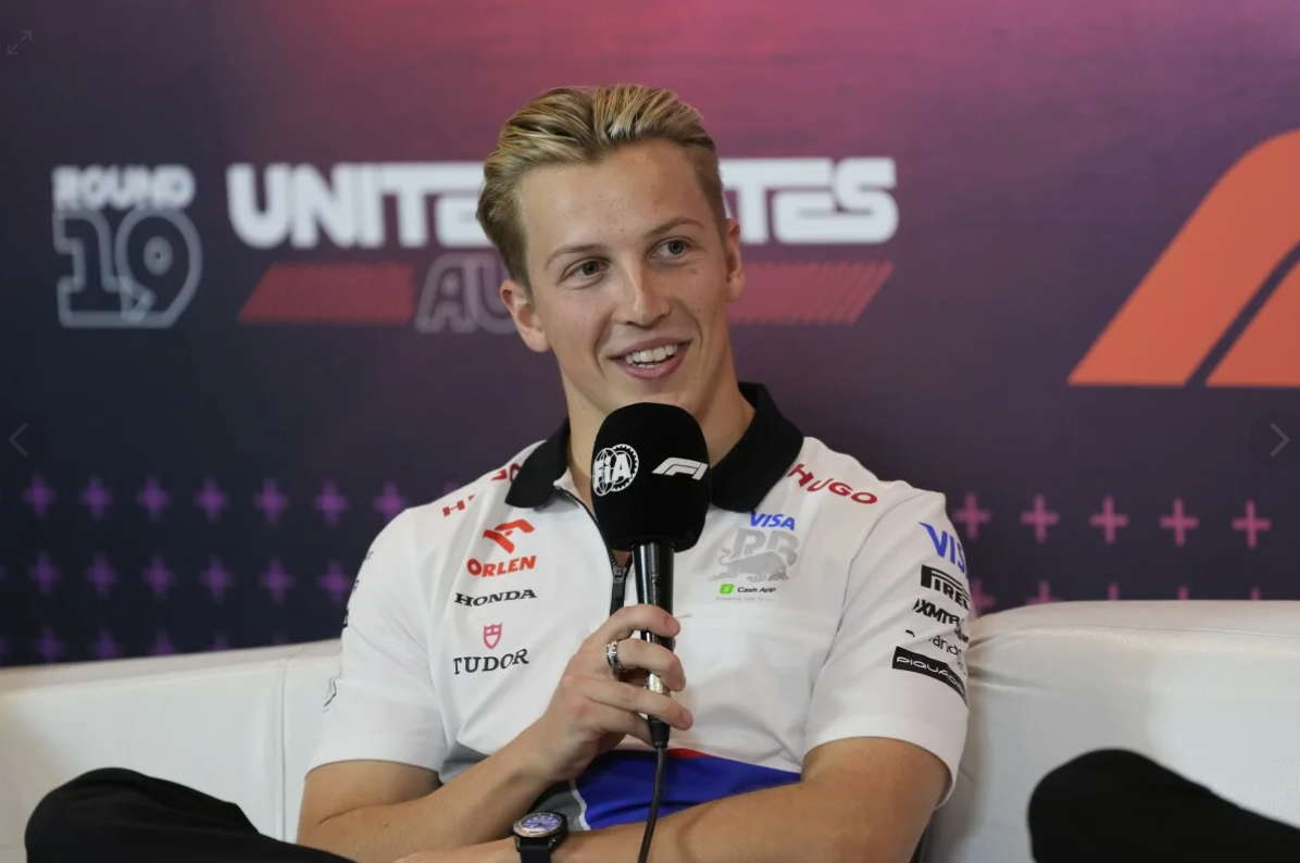 Liam Lawson im Gespräch mit Teammitgliedern im Fahrerlager