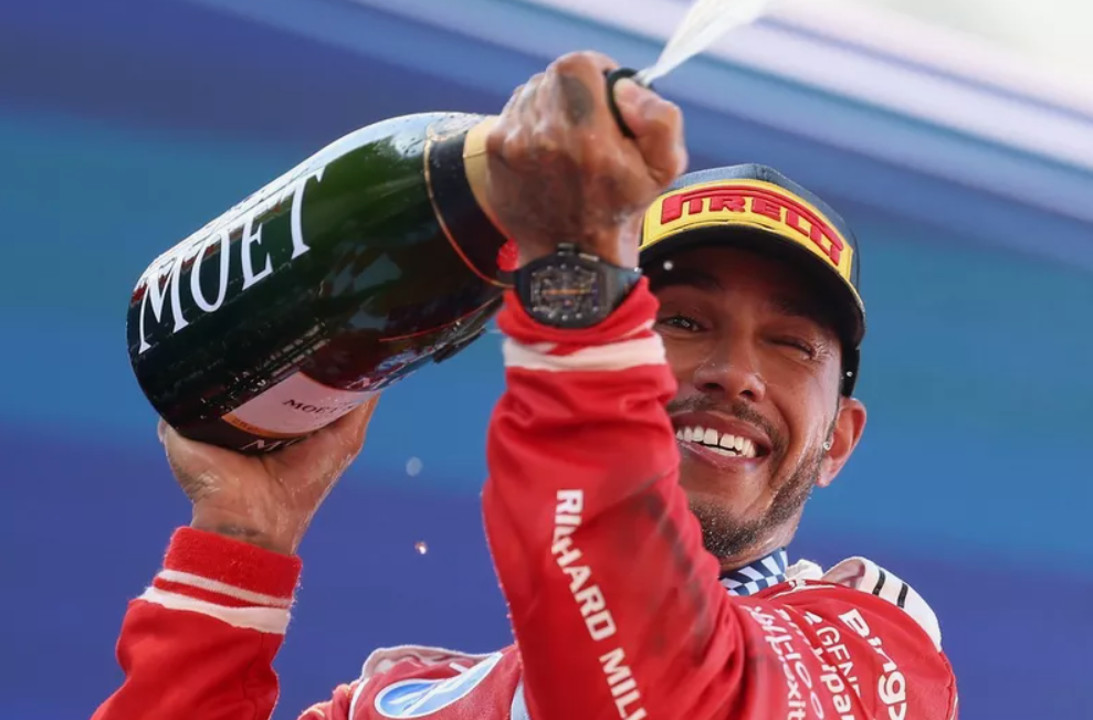 Inženýr Formule 1 analyzuje data a komunikuje s Lewisem Hamiltonem přes týmový vysílačku v garáži.