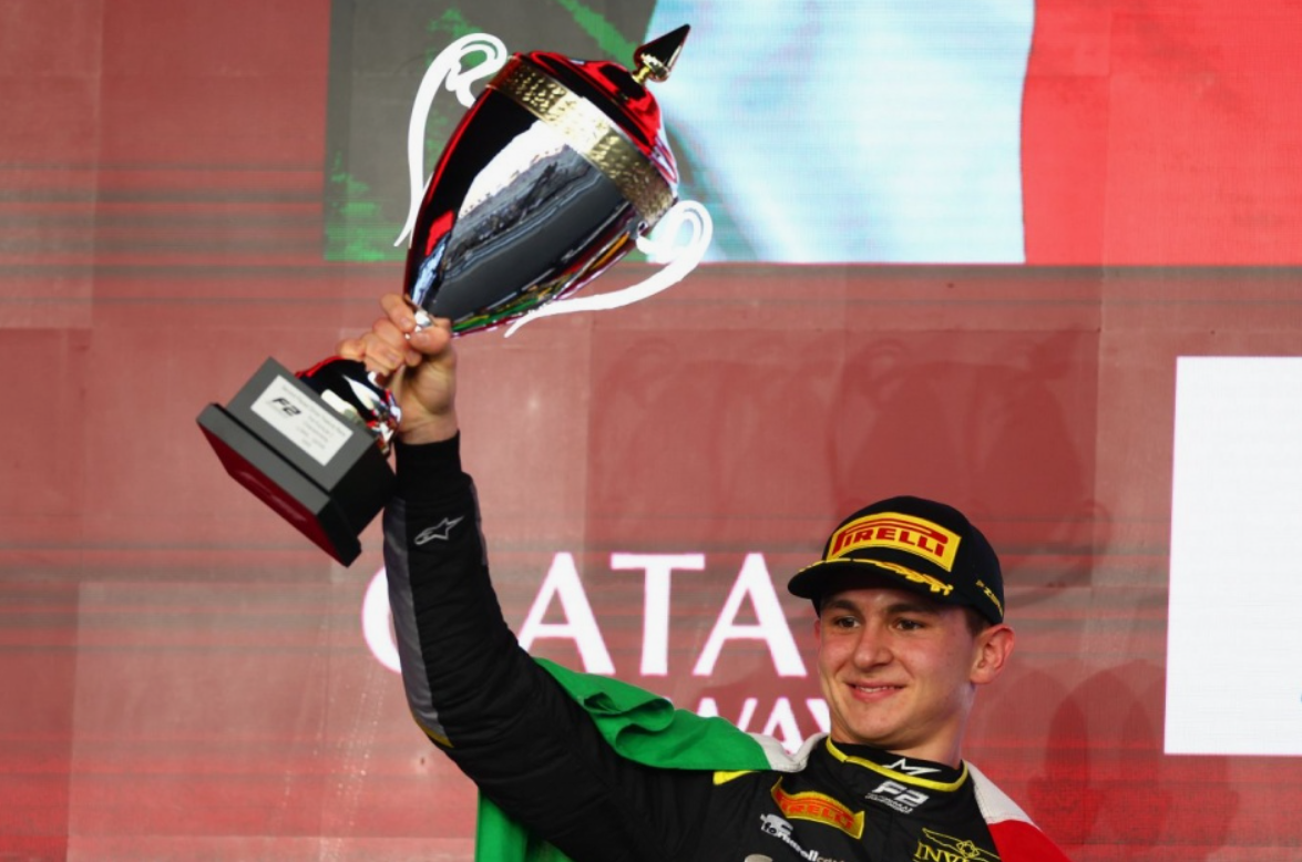 Mașină Haas de Formula 1 din generația anterioară pe pistă în timpul unei sesiuni de teste, condusă de un campion de Formula 2.