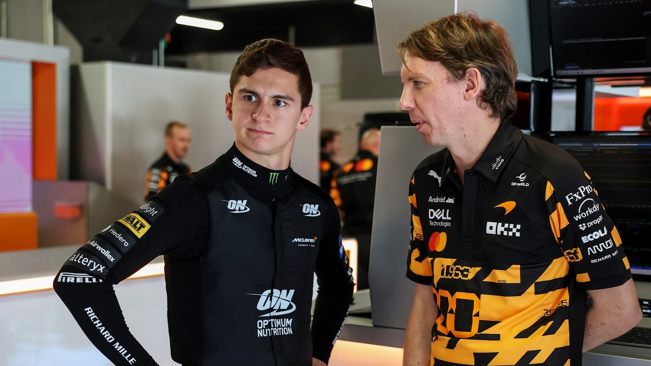 Two young drivers stand together in Formula 1 team clothing