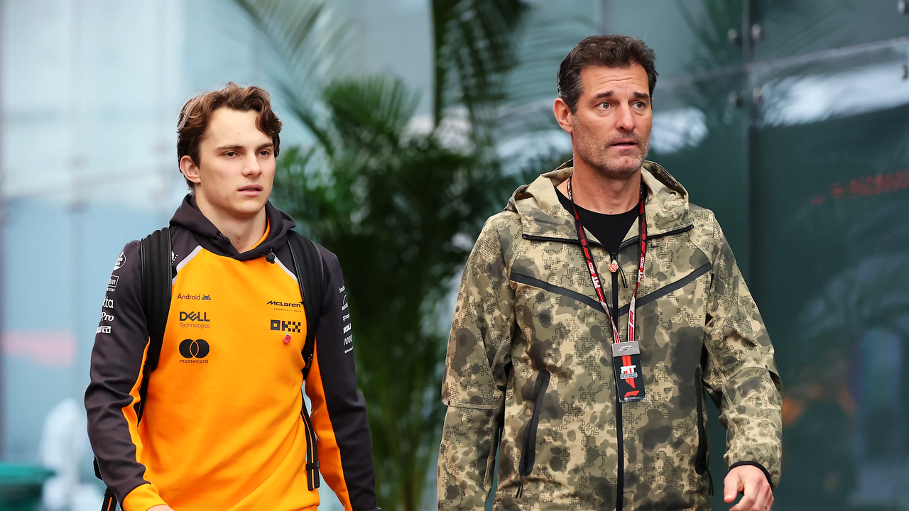 Oscar Piastri se sprehaja z Markom Webberjem med dirko Formule 1