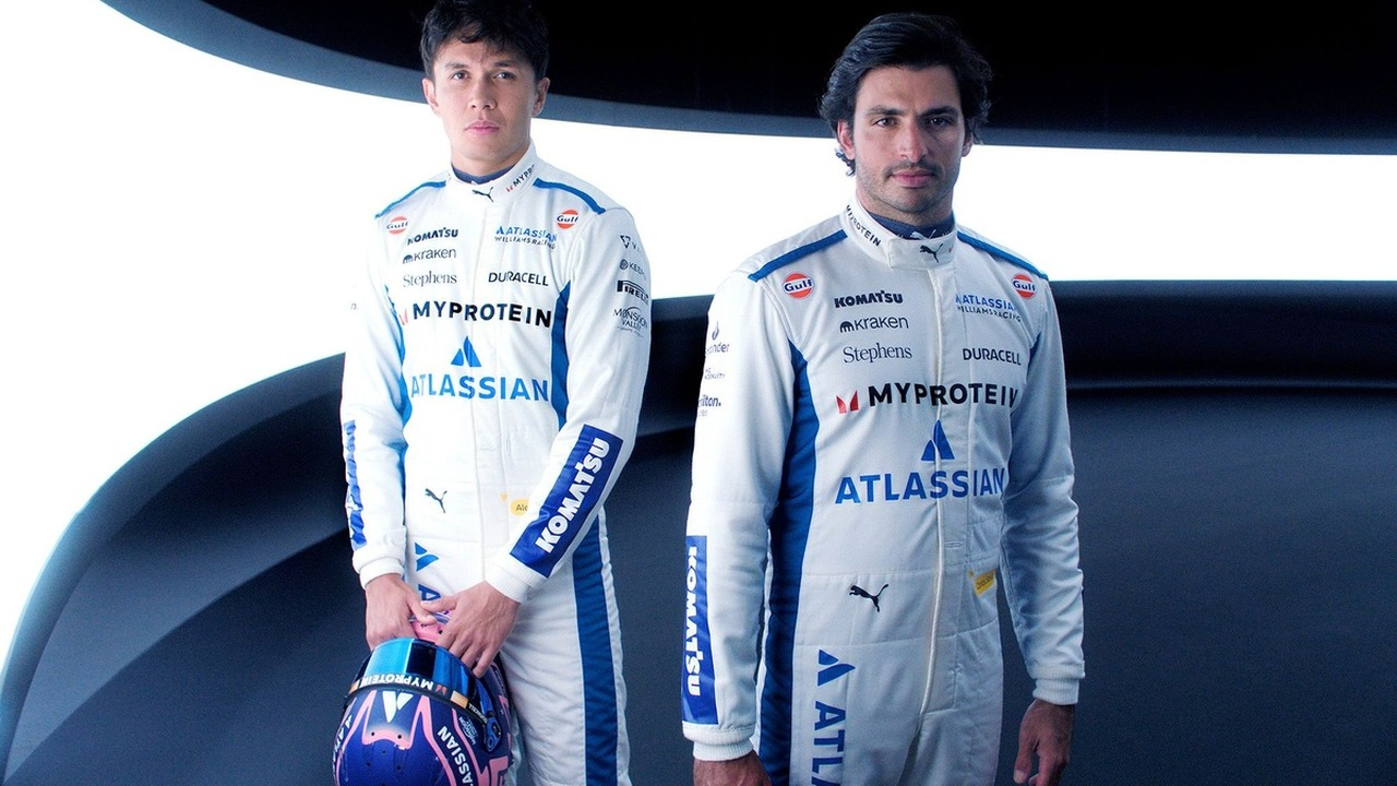 Alex Albon and Carlos Sainz stand together in Williams race suits