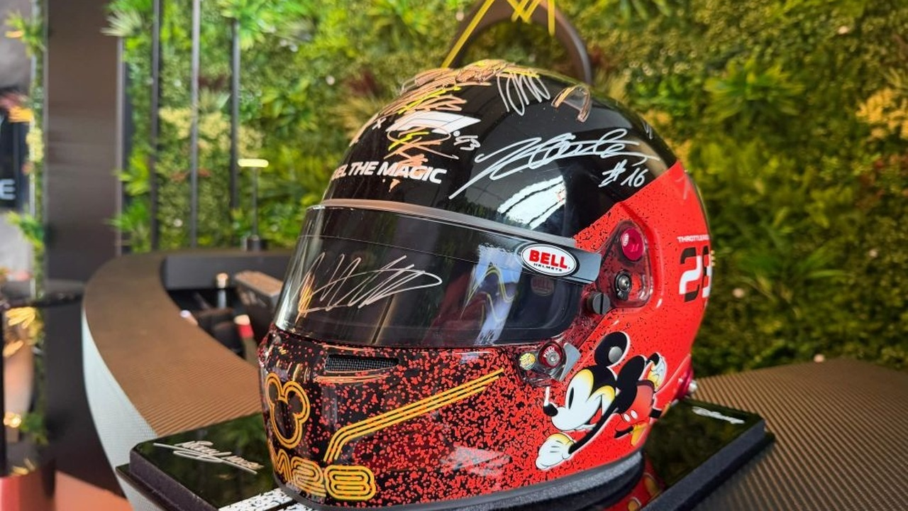 사인이 담긴 Disney Formula 1 헬멧이 전시 테이블에 놓여 있습니다