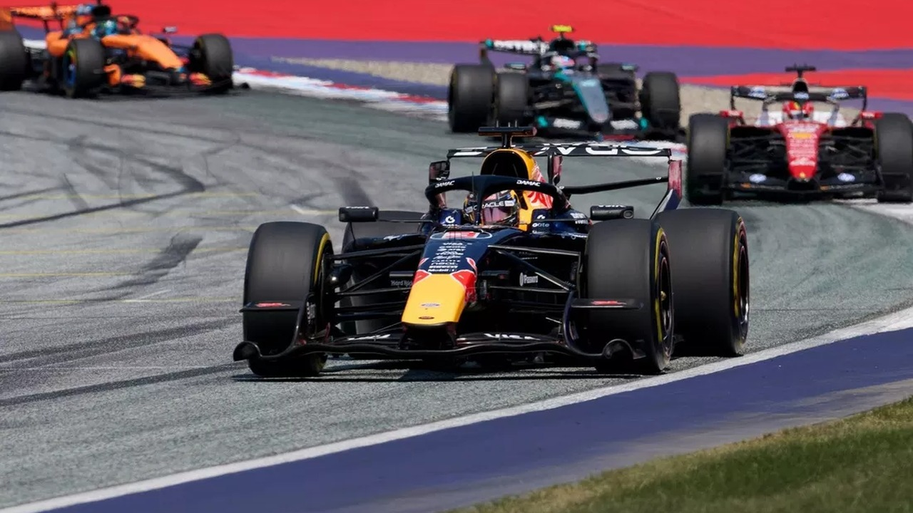 Formula 1 cars drive through a corner during a race