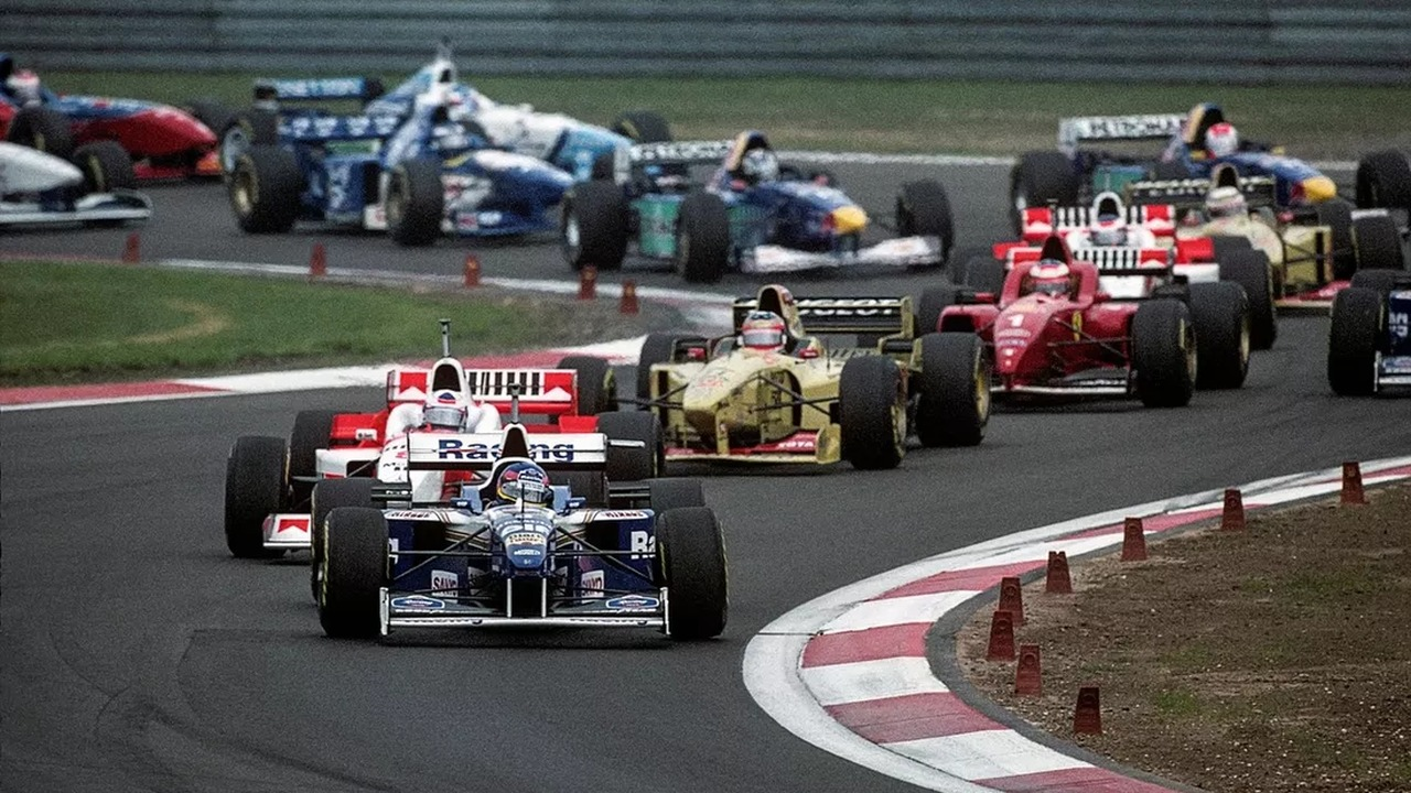 Formula 1 cars follow each other through a circuit corner