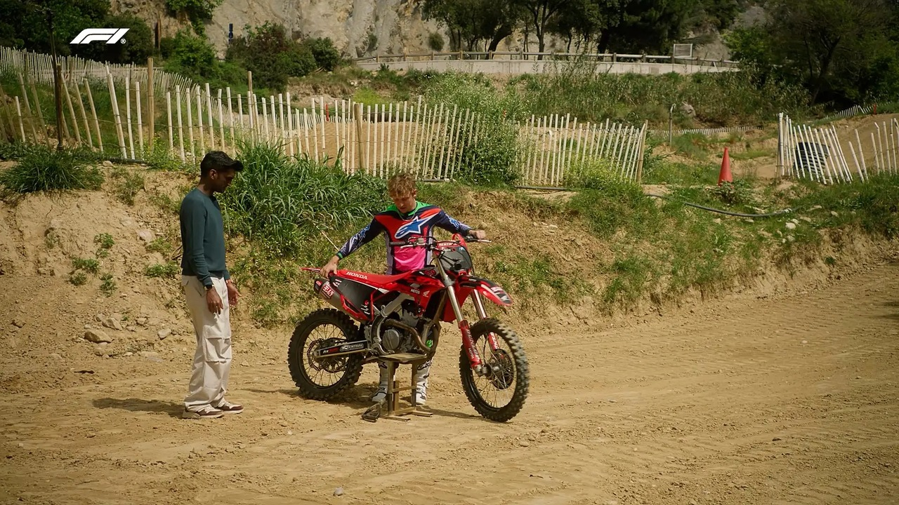 Liam Lawson steht neben einem Motorrad auf einer Dirt-Strecke