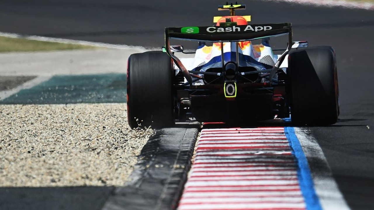 A Racing Bulls Formula One car drives over a kerb